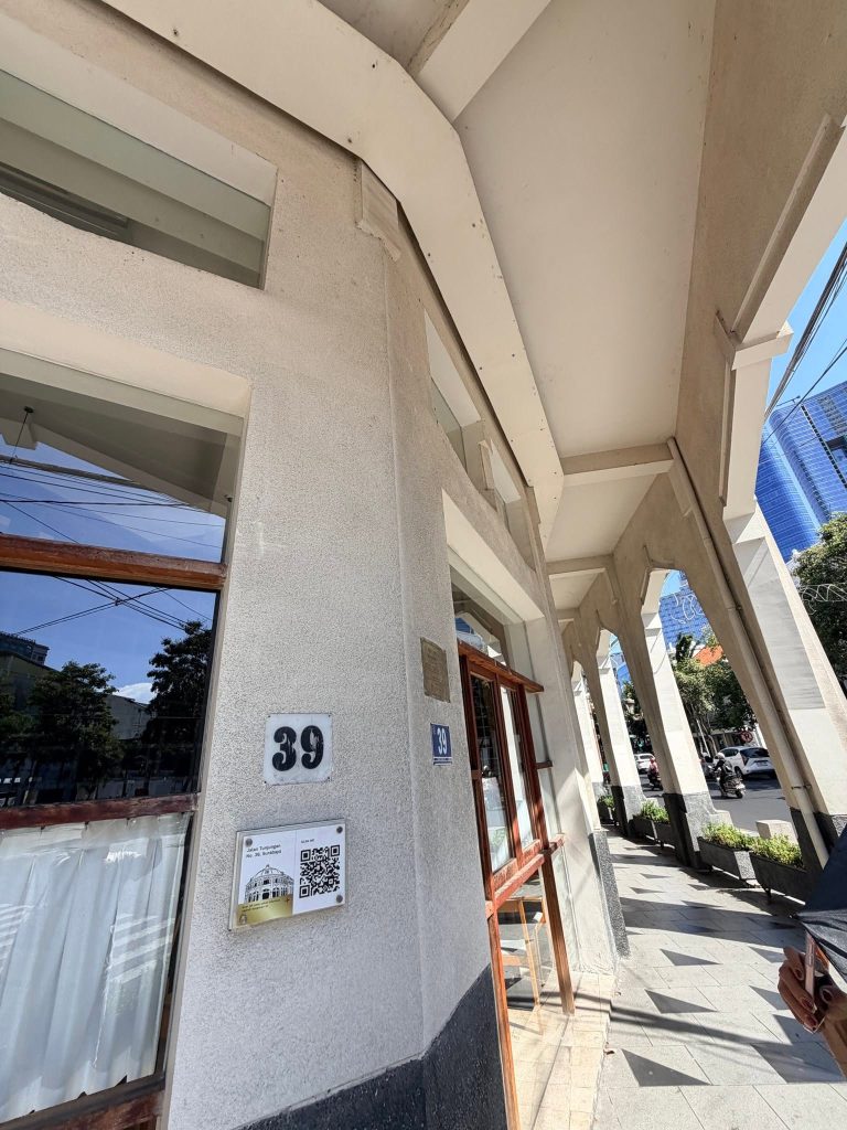 泗水 Jalan Tunjungan No. 39 門牌與 QR 銘牌,後方可見現代高樓