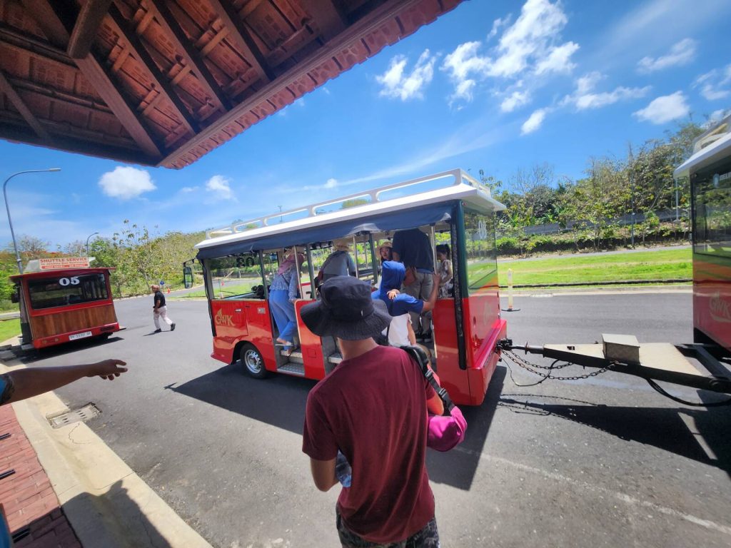 峇里島神鷹廣場傳統屋頂候車亭與紅色園區接駁車