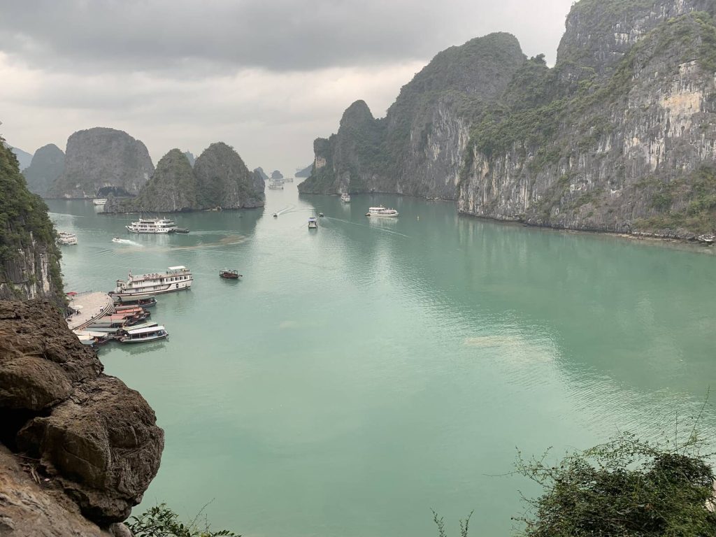 從下龍灣驚訝洞出口平台俯瞰石灰岩島嶼與遊船