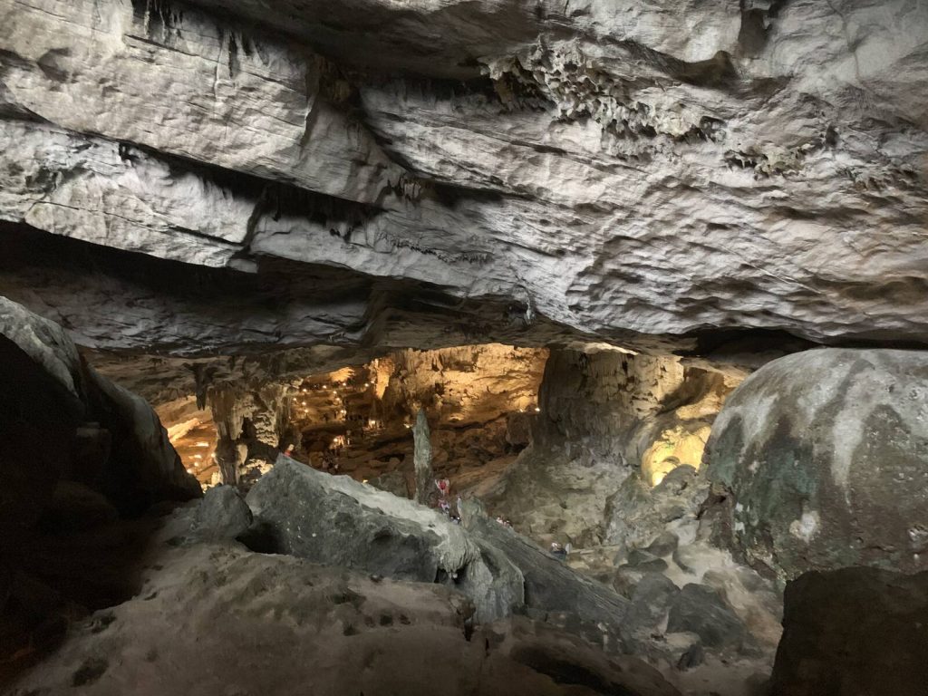 從低矮岩層下方回望驚訝洞內的暖色燈光